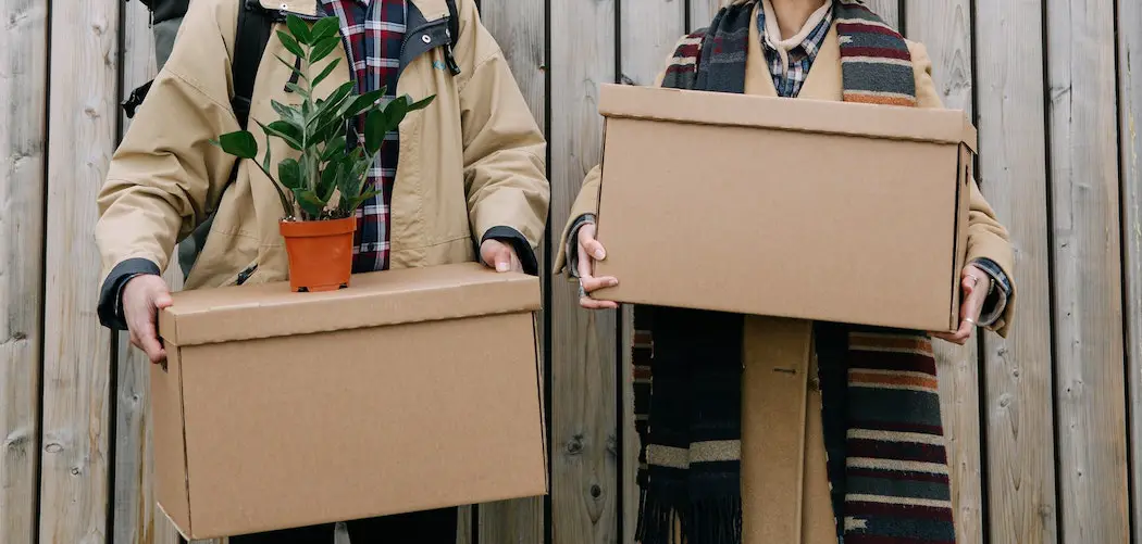 man and woman moving boxes and plant in cold winter